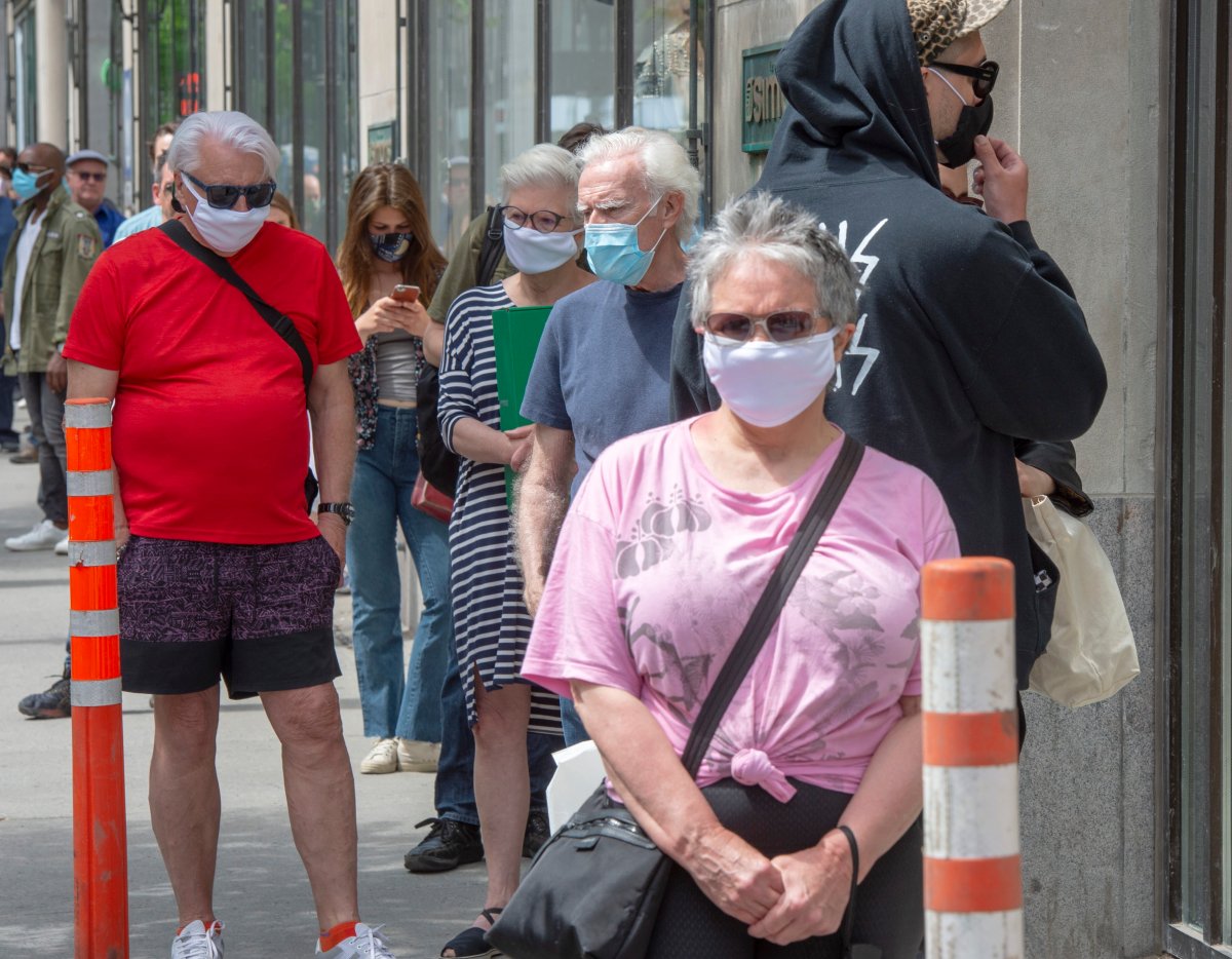 Customers line up at Simon's department store as many non-essential businesses are allowed to re-open Monday May 25, 2020 in Montreal. 