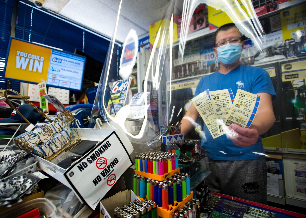 A convince store owner hands OLG 649 and Lotto Max tickets at his store during the COVID-19 pandemic in Mississauga, Ont., on Monday, May 25, 2020. Premier Doug Ford's government gives $500M loan to Ontario Lottery and Gaming. 