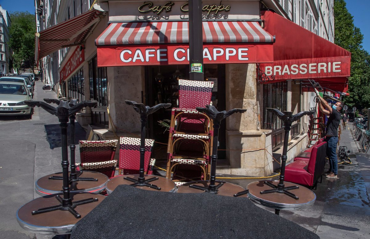 A man wears a mask to help curb the spread of the coronavirus cleans the terrace of his restaurant in Paris, Friday, May 29, 2020, as France gradually lifts its Covid-19 lockdown.