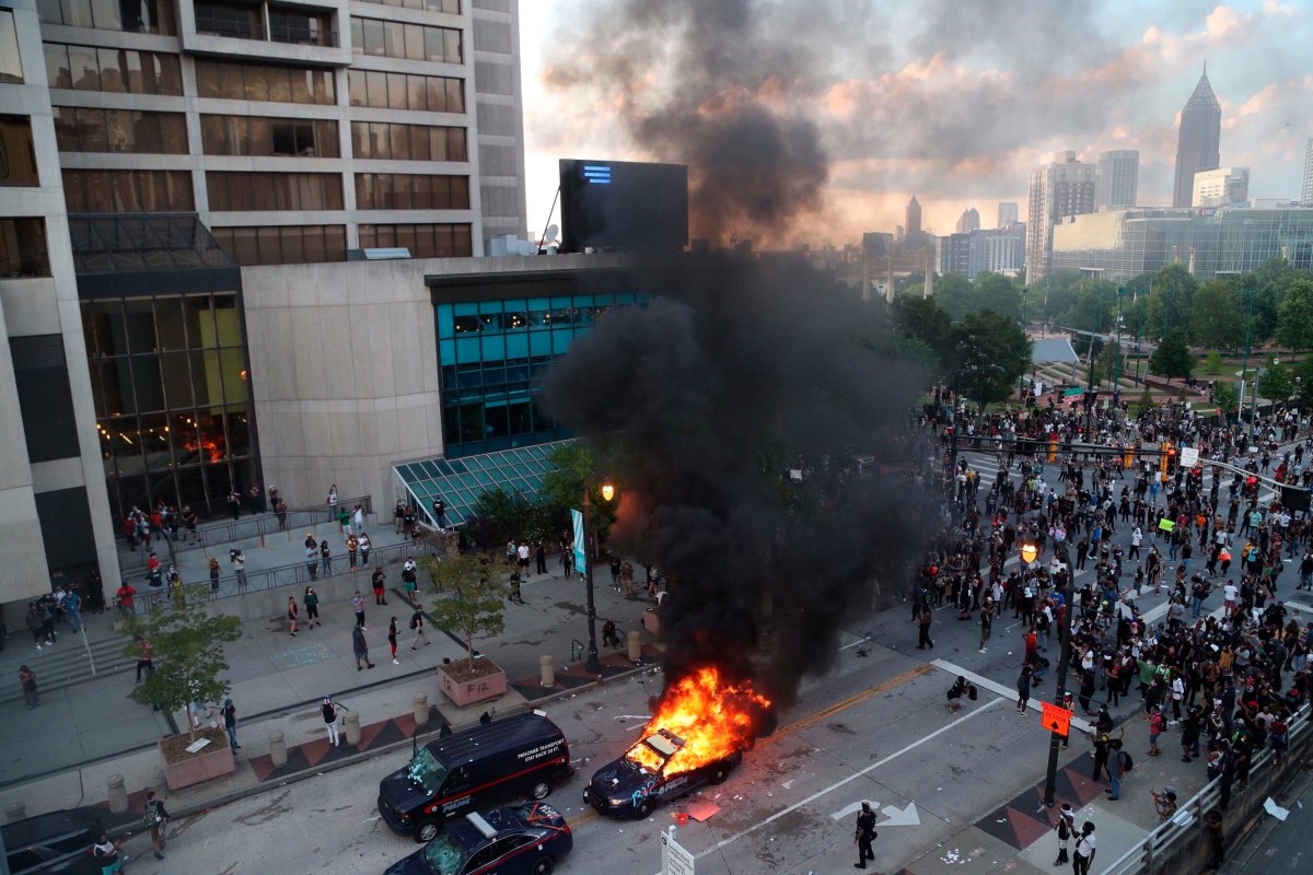 A police car burns after protesters marched to the Georgia State Capitol and returned to the area around the Centennial Olympic Park and CNN center where some confronted police Friday, May 29, 2020, in Atlanta. 