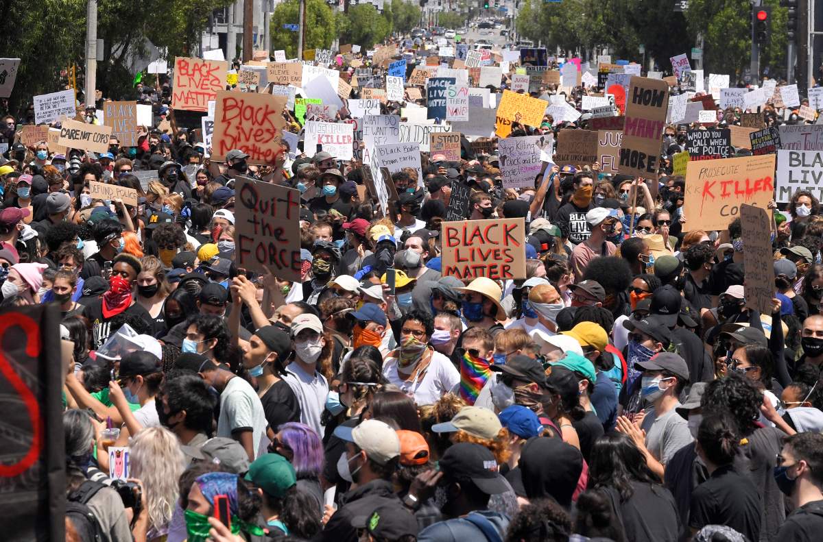 Demonstrators sit in an intersection during a protest over the death of George Floyd, Saturday, May 30, 2020, in Los Angeles.