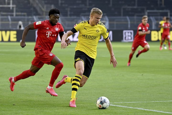 Munich’s Alphonso Davies, left, and Dortmund’s Erling Haaland, right, challenge for the ball during the German Bundesliga soccer match between Borussia Dortmund and FC Bayern Munich in Dortmund, Germany, Tuesday, May 26, 2020.