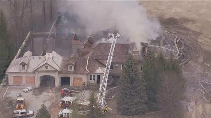Firefighters on scene battling a fire at a home under construction in Aurora.