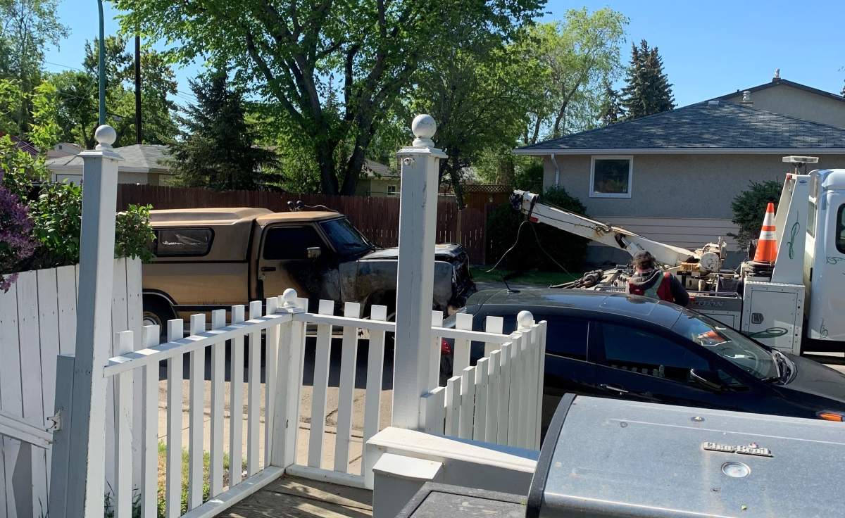 The burned vehicle is shown being towed away Wednesday morning