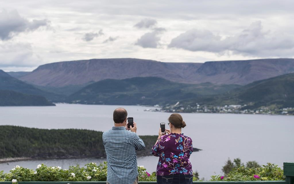 Tourists take pictures with their mobile phones of the Gulf of St. Lawrence in Gros Morne National Park, Newfoundland and Labrador, on Monday, August 15, 2016.