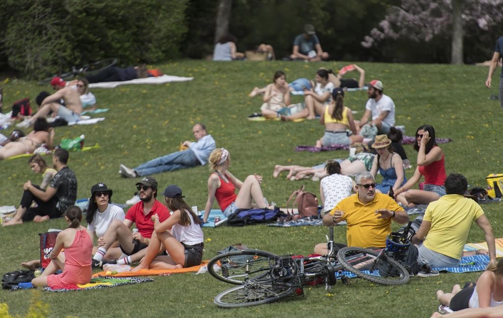 People enjoy a warm sunny day in a city park in Montreal, Sunday, May 24, 2020.