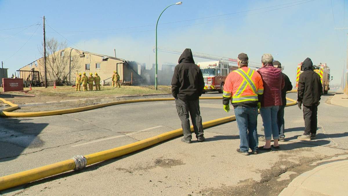 Onlookers watch as the Regina Elks hall burns to the ground on May 3, 2020.