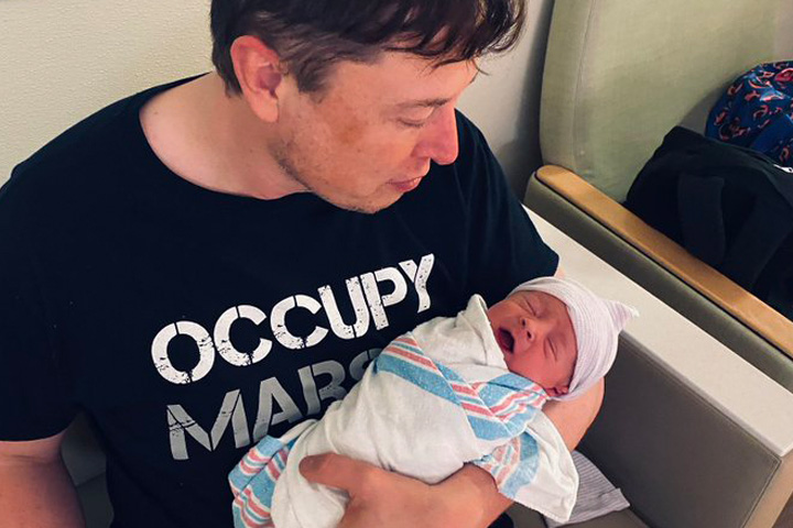 Elon Musk is shown with his child after girlfriend Grimes gave birth on May 4, 2020.