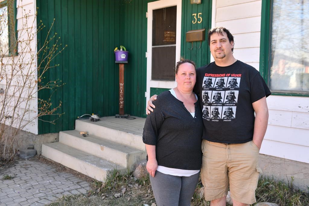 Homeowners Cora and Alec Dion pose by their home in Fort McMurray, Alta., on May 8, 2020. The Dions had about five feet of water in their basement as a result of recent flooding in downtown Fort McMurray. This marked the second time the couple faced evacuation from their home since the Horse River wild fire of May 3, 2016. THE CANADIAN PRESS/Greg Halinda.