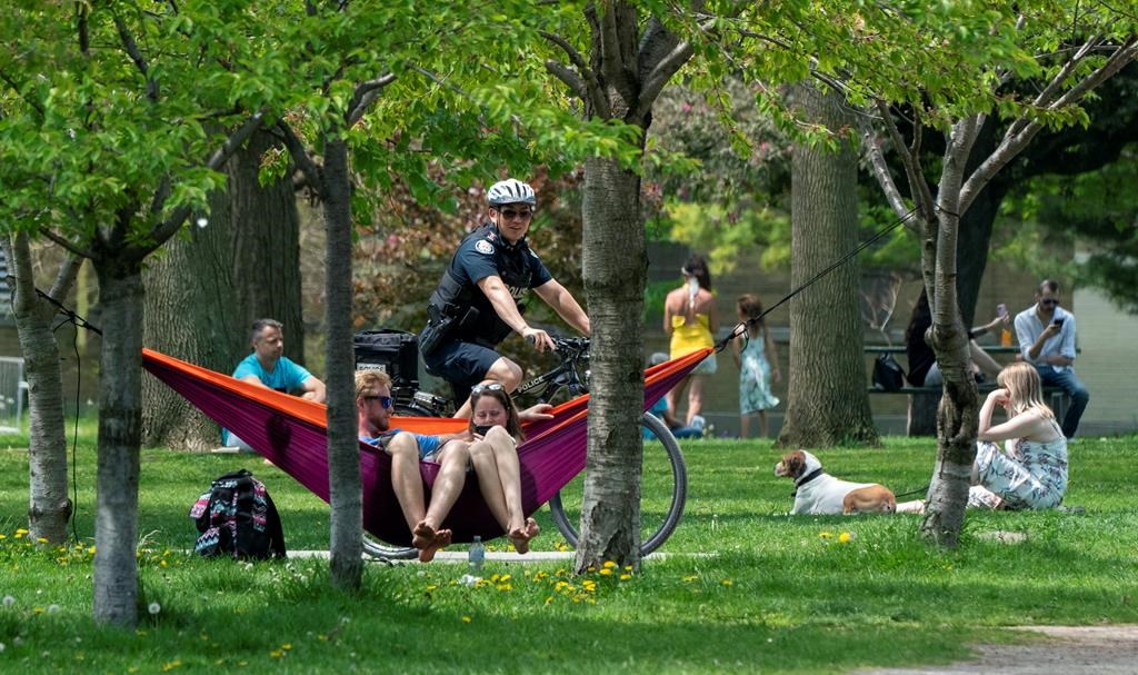 A police officer patrols Trinity Bellwoods Park in Toronto on Sunday, May 24, 2020. Warm weather and a reduction in COVID-19 restrictions has many looking to the outdoors for relief. THE CANADIAN PRESS/Frank Gunn