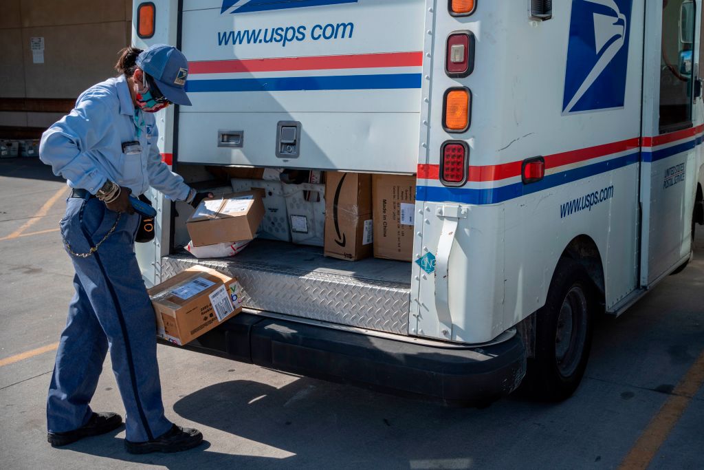 A United States Postal Service mail carrier finishes up loading her truck amid the coronavirus pandemic on April 30, 2020, in El Paso, Texas.