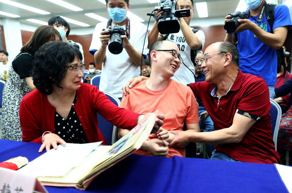 This photo taken on May 18, 2020 shows Mao Yin speaking with his mother Li Jingzhi and father Mao Zhenping in Xian, in China’s northern Shaanxi province. A Chinese man who was kidnapped as a toddler 32 years ago has been reunited with his biological parents, after police used facial recognition technology to track him down.