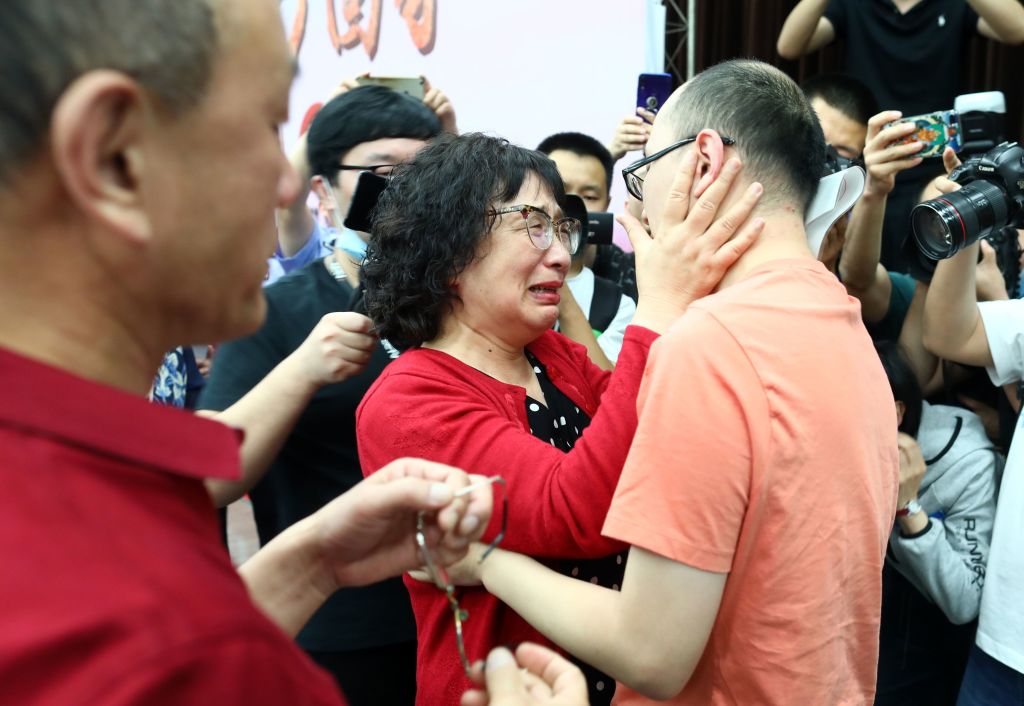 This photo taken on May 18, 2020 shows Mao Yin reuniting with his mother Li Jingzhi and father Mao Zhenping in Xian, in China's northern Shaanxi province.  A Chinese man who was kidnapped as a toddler 32 years ago has been reunited with his biological parents, after police used facial recognition technology to track him down.