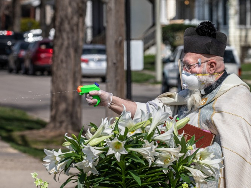 Rev. Tom Pelc of St. Ambrose Parish in Detroit, Mich., blessed churchgoers with a water gun full of holy water.
