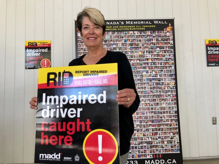 Heather Tatham with MADD Regina holds up one of the mobile signs unveiled on May 21, 2020. Tatham’s husband, Garry, was killed by a drunk driver in 2014.