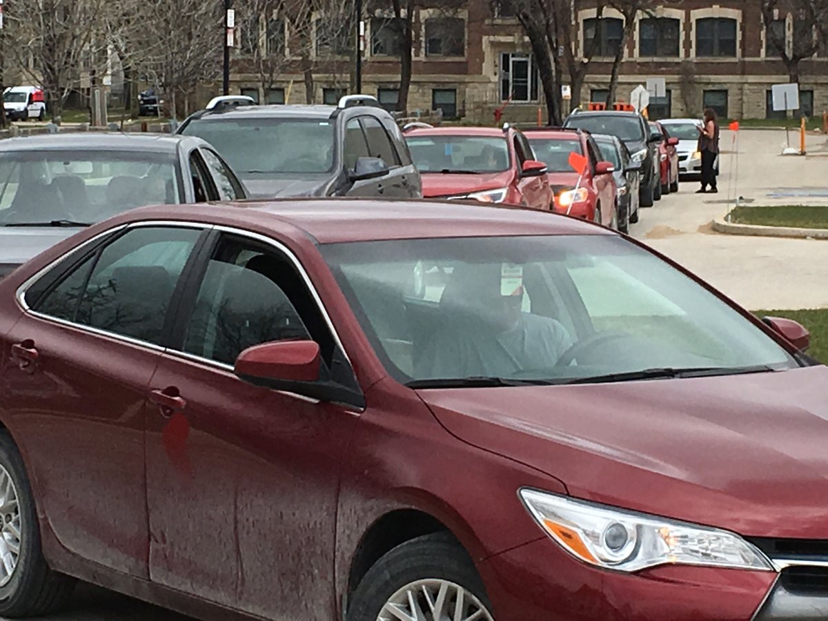Vehicles wait in the drive-through line at the Manitoba COVID-19 testing site on Main Street Thursday afternoon.