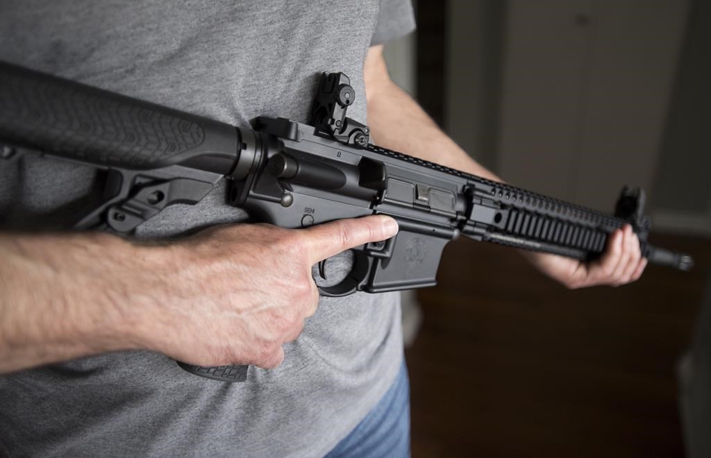 A restricted gun licence holder holds a AR-15 at his home in Langley, B.C. Friday, May 1, 2020.