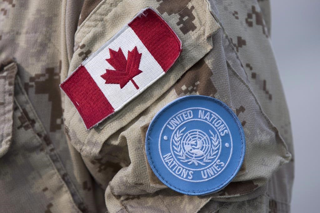 Canadian flag and the UN flag is shown on the sleeve of a Canadian soldier's uniform before boarding a plane at CFB Trenton in Trenton, Ont., on July 5, 2018.