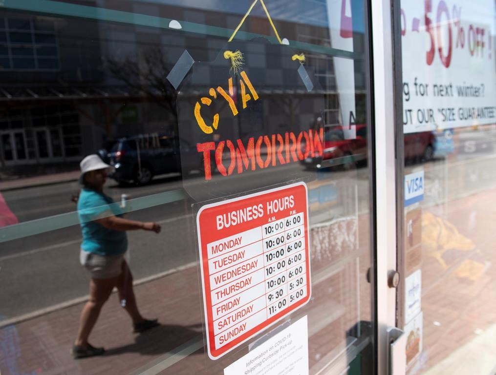 A sign on a closed shop welcomes shoppers to return tomorrow, in Ottawa, on Monday, May 18, 2020.