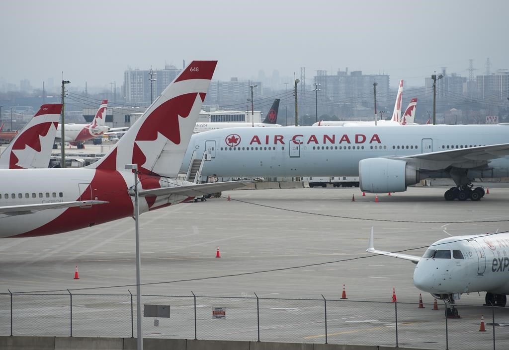 Air Canada planes sit on the tarmac at Pearson International Airport in Toronto on Wednesday, April 8, 2020. The union representing Air Canada flight attendants says the airline will now ask employees to work less, or not at all, as concerns over job security buffet the airline industry. THE CANADIAN PRESS/Nathan Denette.