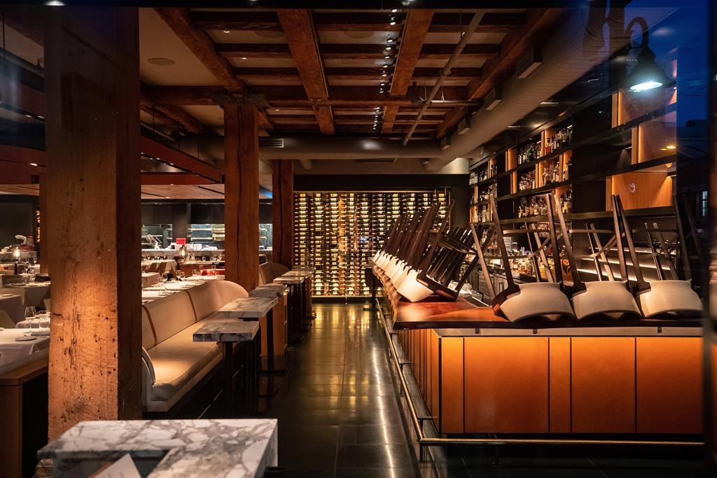Chairs are turned upside down on the bar at a closed restaurant, amid concerns about the spread of the coronavirus, in Vancouver, on Tuesday, March 17, 2020. As some British Columbia businesses prepare to reopen their doors on Tuesday when the province enters the second phase of its COVID-19 restart plan, others say they're holding off while they grapple with new health protocols. THE CANADIAN PRESS/Darryl Dyck.