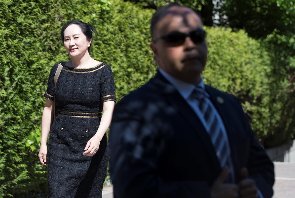 A security guard looks on as Meng Wanzhou, chief financial officer of Huawei, leaves her home to go to B.C. Supreme Court in Vancouver, Wednesday, May 27, 2020. THE CANADIAN PRESS/Jonathan Hayward.