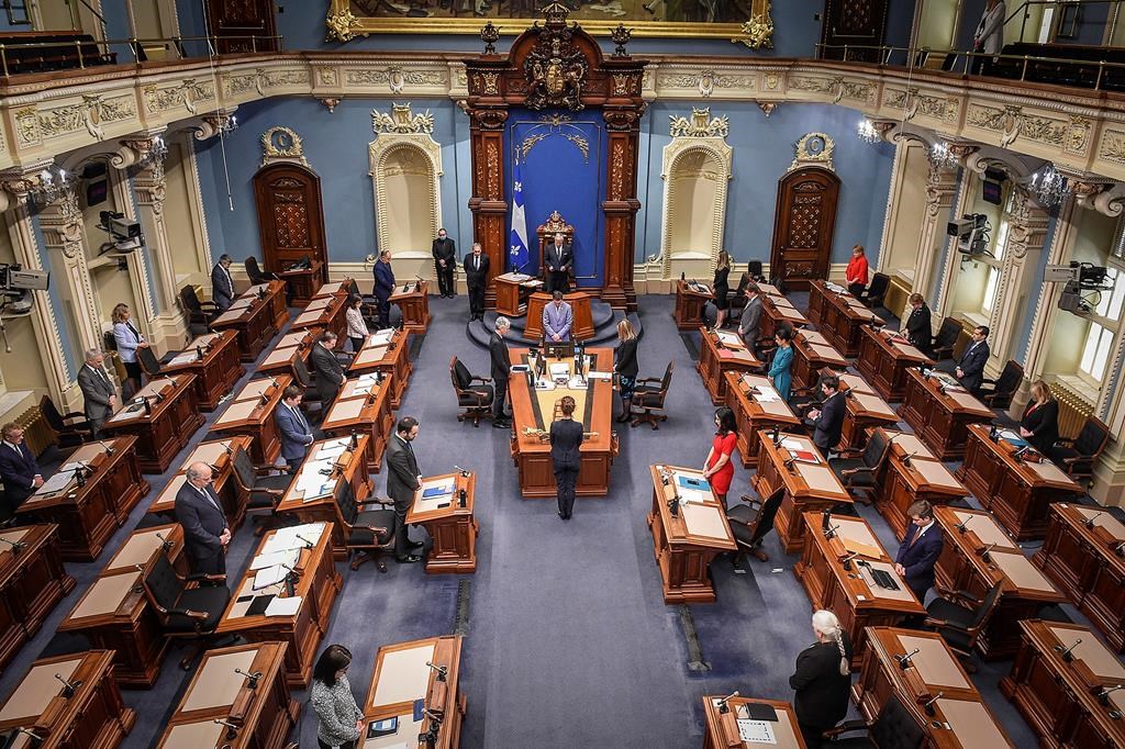 Members of the National Assembly stand in a minute of silence to honor the victims as the legislature resumes with limited attendance of members during the COVID-19 pandemic, Wednesday, May 13, 2020 at the legislature in Quebec City. THE CANADIAN PRESS/POOL Simon Clark.