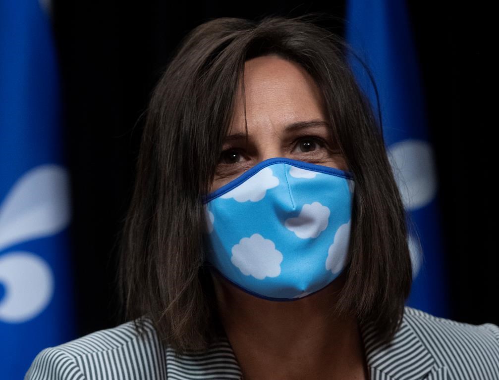Quebec junior Education Minister and minister responsible for the status of women Isabelle Charest walks in wearing a mask.