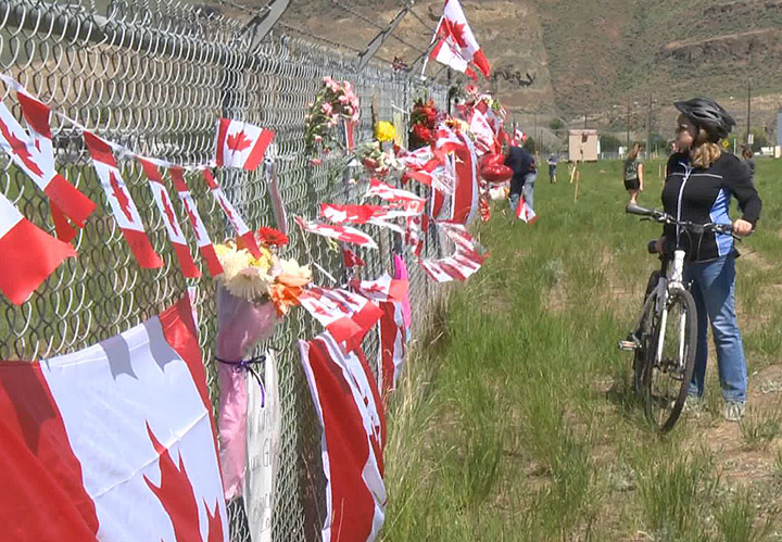 Caroline Vigue takes in the makeshift memorial at Kamloops Airport on Tuesday.