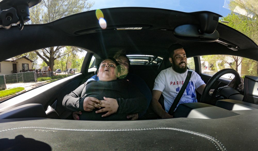 In this photo taken with a camera set up on the dashboard, Adrian Zamarripa, 5, reacts as Jeremy Neves, owner of a Lamborghini Huracan, steps on the gas while Adrian and his mother, Beatriz Flores, were getting the ride in Ogden, Utah, Tuesday, May 5, 2020.