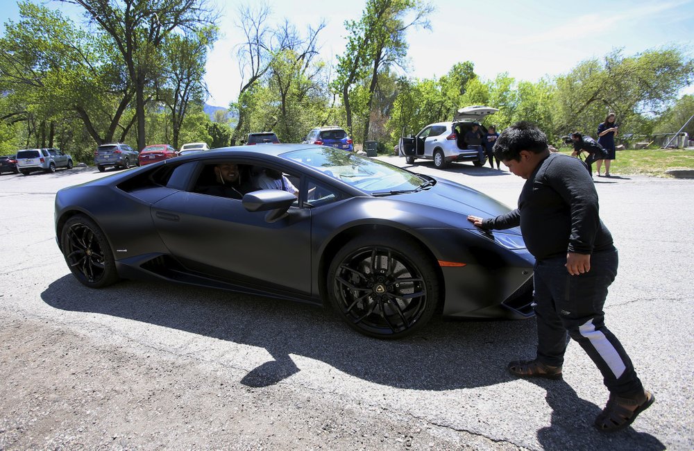 Adrian Zamarripa touches the front of Jeremy Neves’ Lamborghini Huracan in Ogden, Utah, Tuesday, May 5, 2020. Adrian, who tried to drive his parents’ car to California on Monday and was stopped by the Utah Highway Patrol, got a ride on the Lamborghini on Tuesday from Neves, who heard about the news and drove his car from another county for Adrian.