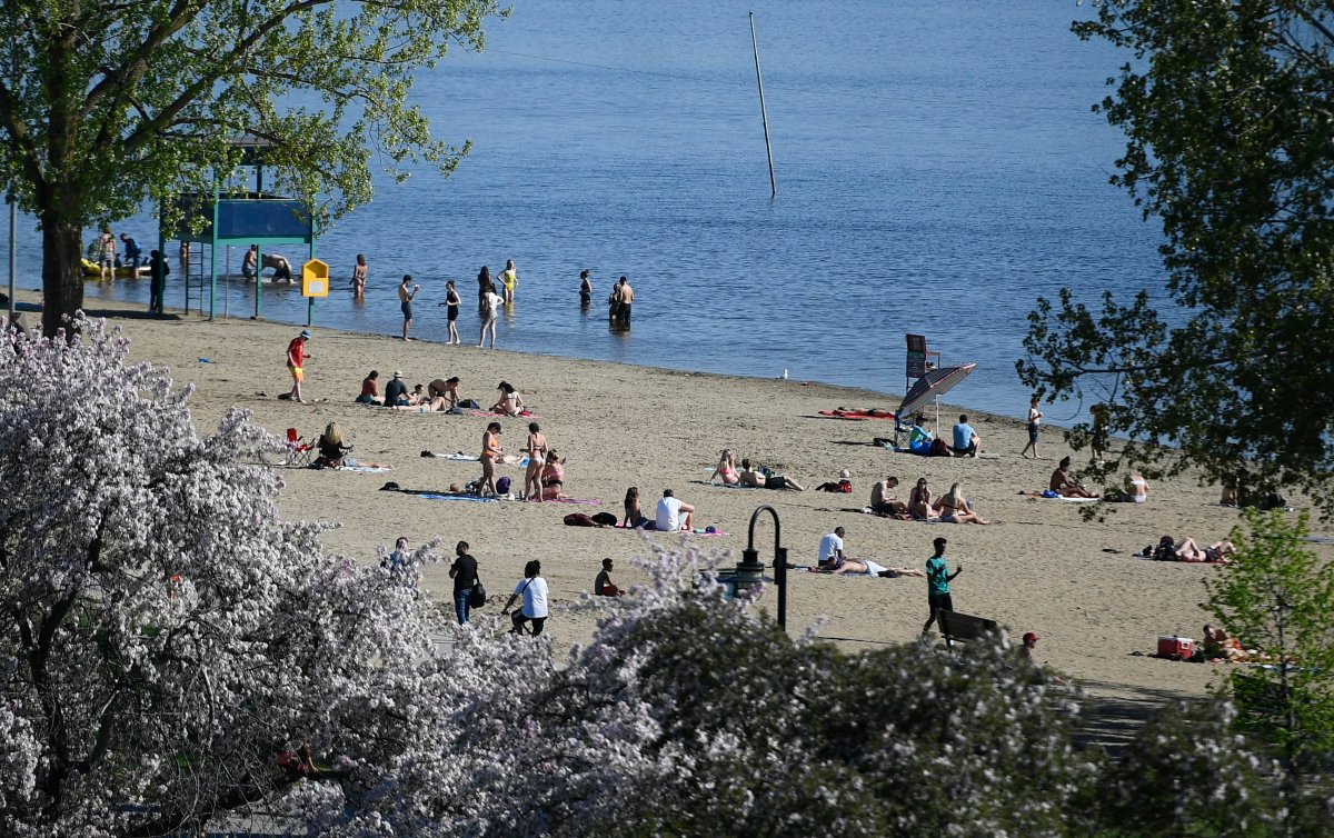 People practice physical distancing as they enjoy the warm weather at Mooney's Bay Beach in Ottawa, on Saturday, May 23, 2020, in the midst of the COVID-19 pandemic.