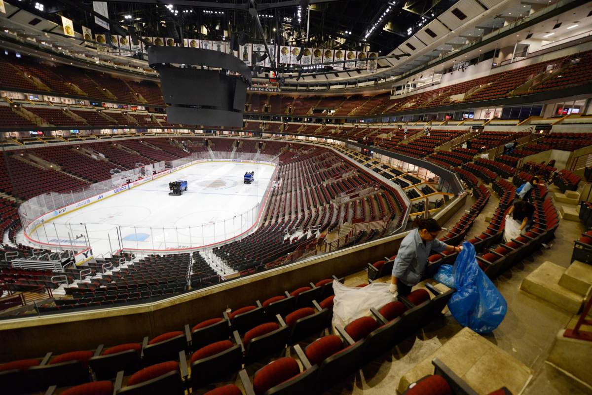 Workers clean up after an NHL hockey game between the Chicago Blackhawks and the San Jose Sharks at the United Center on Wednesday, March 11, 2020, in Chicago. 