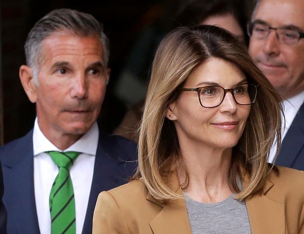 FILE - In this April 3, 2019, file photo, actress Lori Loughlin, front, and her husband, clothing designer Mossimo Giannulli, left, depart federal court in Boston.