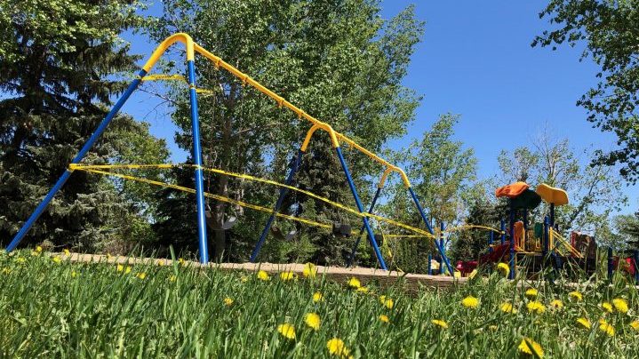 A swing set and play structure is taped off to prevent use during the coronavirus pandemic.