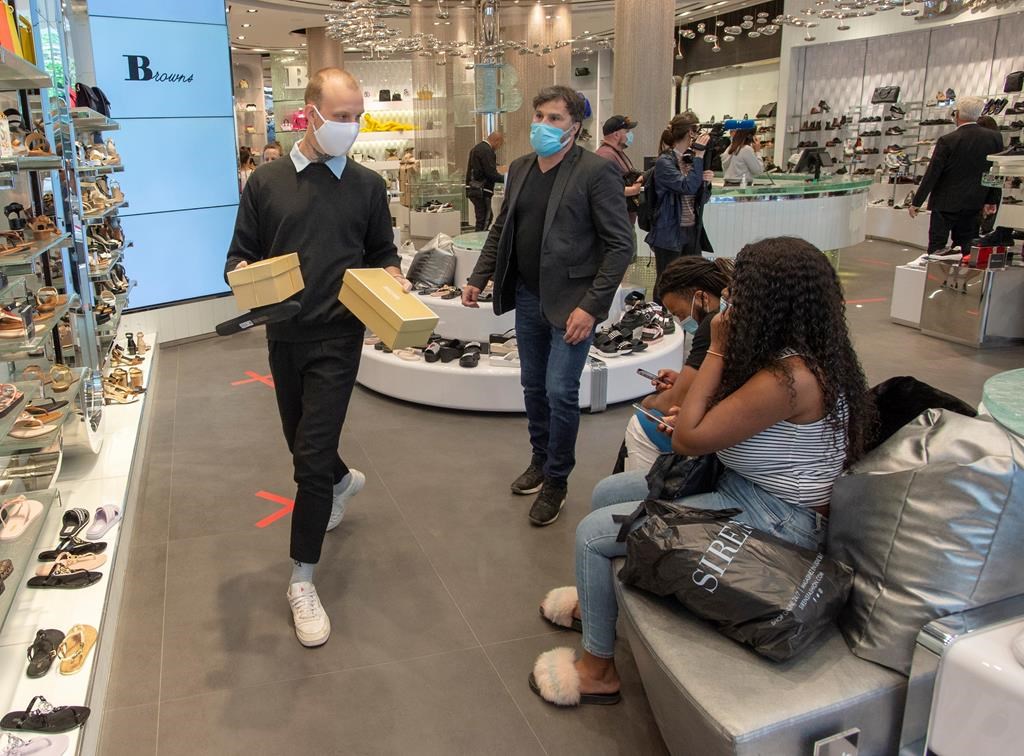 Customers shop for shoes at Brown's shoe store as many non-essential businesses are allowed to reopen Monday, May 25, 2020 in Montreal.