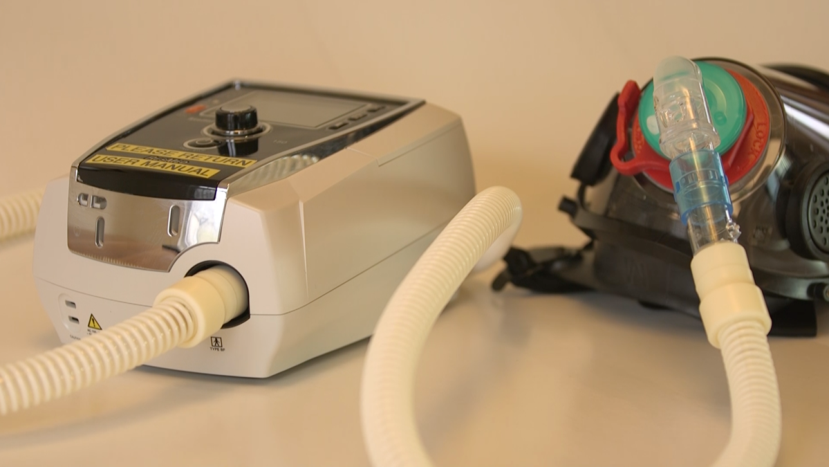 A photo showing the mask attached to a non-invasive ventilator machine.