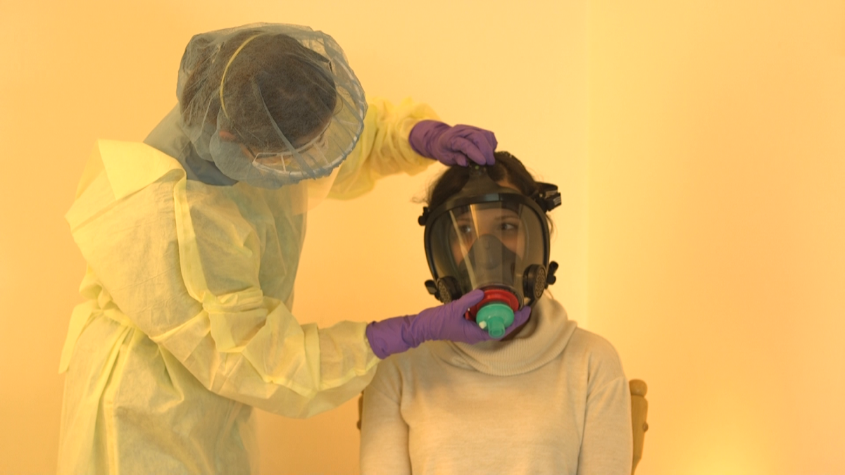 A pair of researchers demonstrate how the mask would be fitted to a patient.