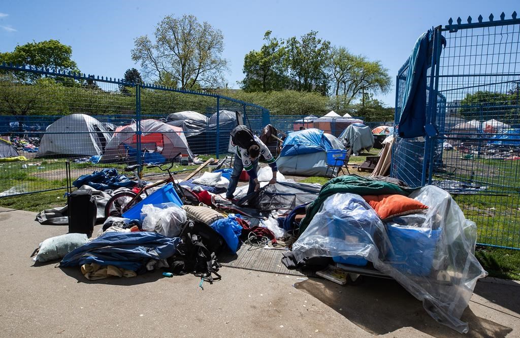 Fencing surrounds a portion of a homeless camp at Oppenheimer Park as a man disassembles a tent, in the Downtown Eastside of Vancouver, on Wednesday, May 6, 2020. The province had set a May 9 deadline to temporarily relocate hundreds of people from tent encampments in Vancouver and Victoria to hotel and community centre accommodations to protect them from the ongoing COVID-19 pandemic.