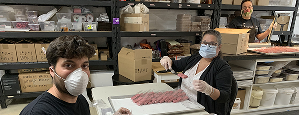 Volunteers Rita Parent, David Santos and Antonio Santos packaging raspberry velvet chocolates.