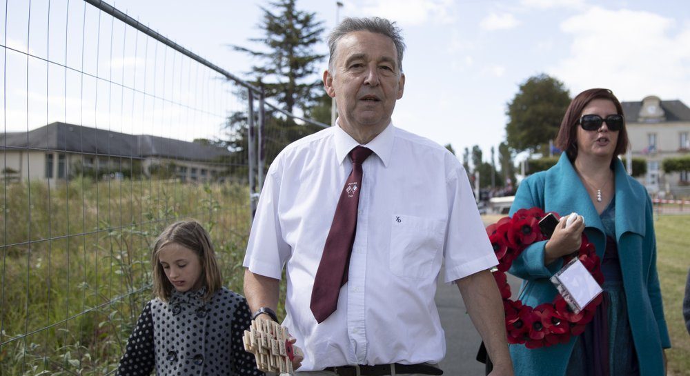 British expatriate Steven Oldrid, centre, carries wooden crosses with names of Second World War dead as he walks to the local war cemetery in Benouville, Normandy, France on Saturday, June 6, 2020. 