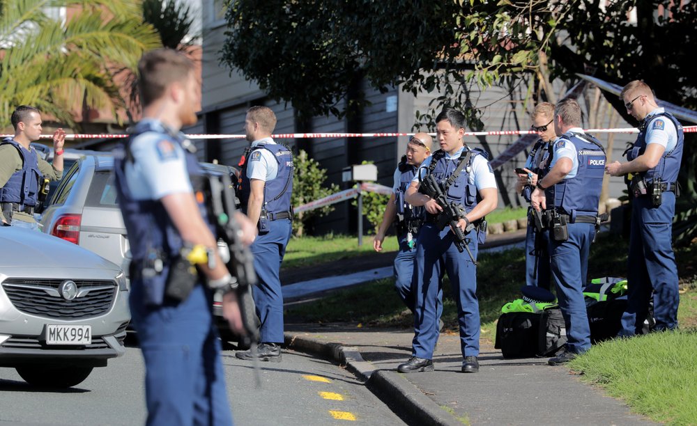 Armed police gather at the scene of a shooting incident following a routine traffic stop in Auckland, New Zealand, Friday, June 19, 2020. New Zealand police say a few officers have been shot and seriously injured and a suspect is on the run. 