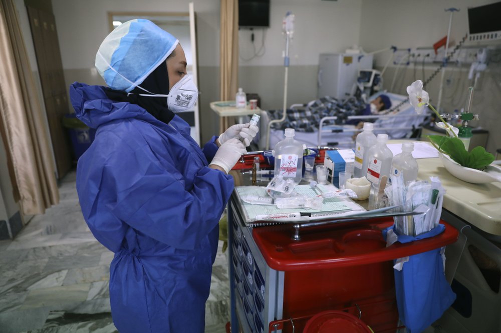 In this Tuesday, June 16, 2020, photo, a nurse prepares medicines for COVID-19 patients at the Shohadaye Tajrish Hospital in Tehran, Iran. After months of fighting the coronavirus, Iran only just saw its highest single-day spike in reported cases after Eid al-Fitr, the holiday that celebrates the end of Ramadan. 