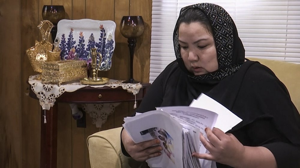 In this image from video, Zumret Dawut, a Uighur from China’s far western Xinjiang region, holds documents she brought with her, at her new home in Woodbridge, Va., on Monday, June 15, 2020. Dawut says in China, she was forcibly sterilized for having a third child after being released from a Xinjiang detention camp.