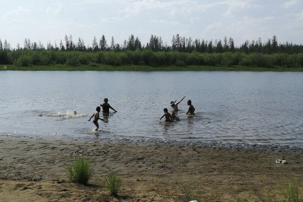 In this handout photo provided by Olga Burtseva, children play in the Krugloe lake outside Verkhoyansk, the Sakha Republic, about 4660 kilometers northeast of Moscow, Russia, Sunday, June 21, 2020. A Siberian town that endures the world's widest temperature range has recorded a new high amid a hear wave that is contributing to severe forest fires. Russia's meteorological service said the thermometer hit 38 Celsius on Saturday in Verkhoyansk, in the Sakha Republic about 4660 kilometers northeast of Moscow.