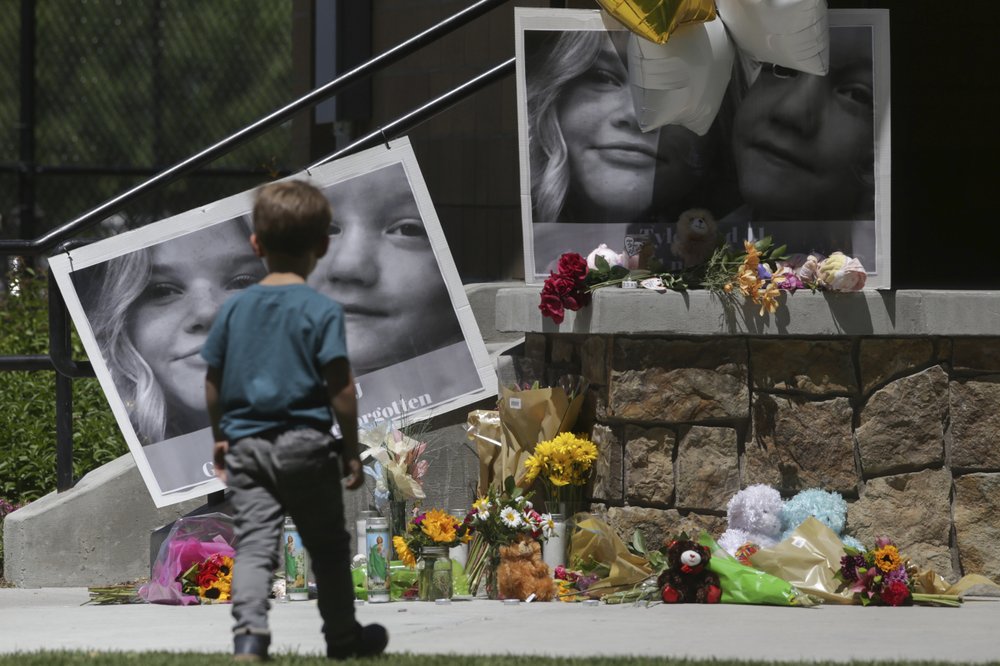 A boy checks out a memorial for Tylee Ryan, 17, and Joshua "JJ" Vallow, 7, at Porter Park in Rexburg, Idaho on Thursday, June 11, 2020.