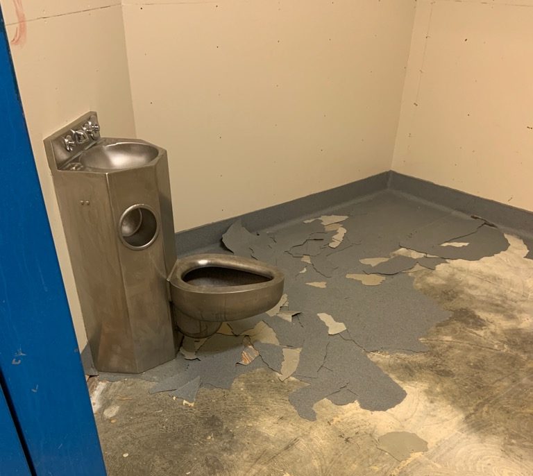 Damage to the floor of a cell at an RCMP detachment.
