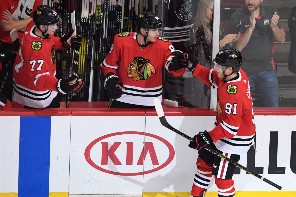 Chicago Blackhawks' Drake Caggiula (91) celebrates with teammates Patrick Kane (88) and Kirby Dach (77) on the bench after scoring a goal during the second period of an NHL hockey game against the Washington Capitals, Sunday, Oct. 20, 2019, in Chicago. 