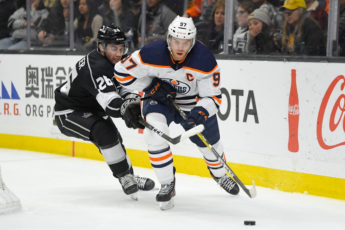 Edmonton Oilers center Connor McDavid, right, moves the puck while under pressure from Los Angeles Kings defenseman Sean Walker during the third period of an NHL hockey game Sunday, Feb. 23, 2020, in Los Angeles. The Oilers won 4-2. (AP Photo/Mark J. Terrill).