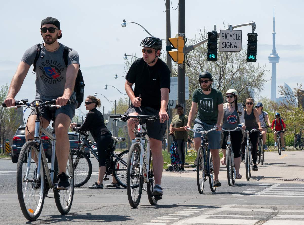 Cyclists negotiate a road crossing on a bike path in Toronto on Saturday, May 23, 2020.
